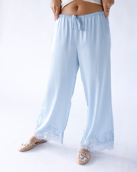 Light blue wide-leg satin pants with lace hem trim and drawstring waist