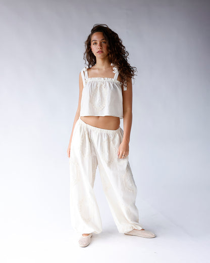 White wide-leg pants with eyelet embroidery, elastic waist, worn with matching crop top
