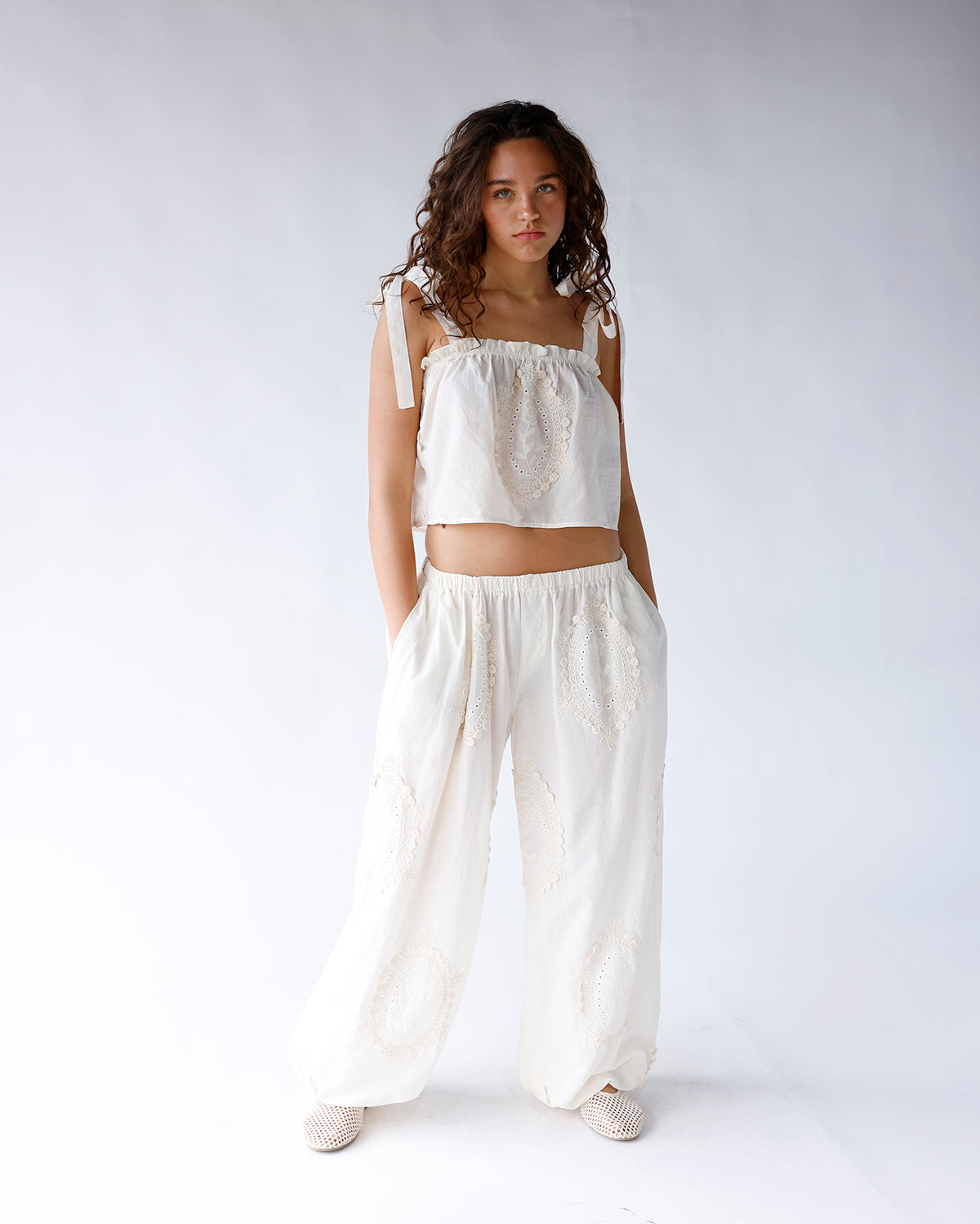 White wide-leg dressy pants with eyelet lace appliqué details and elastic waist