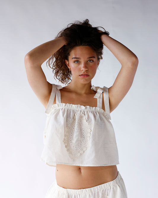 White embroidered crop top with tie straps and floral lace detail