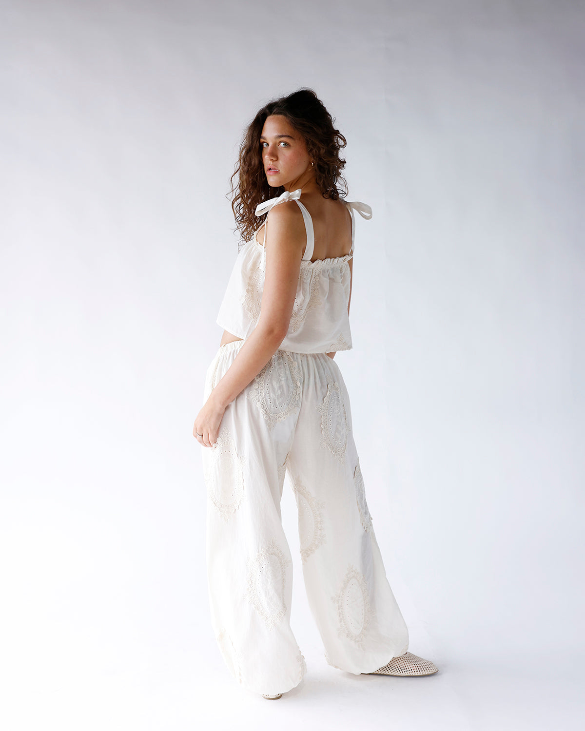 White wide-leg dressy pants with eyelet lace detail, paired with matching crop top