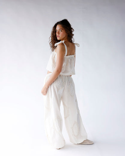 White wide-leg dressy pants with eyelet lace detail, paired with matching crop top