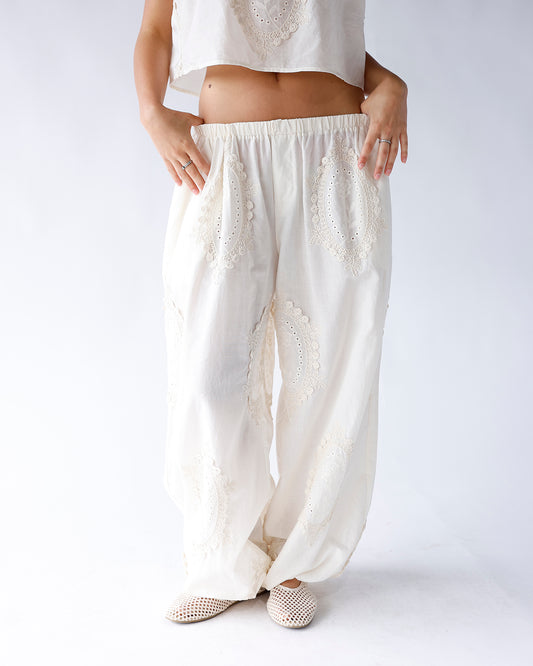 White wide-leg pants with floral eyelet lace embroidery and elastic waistband