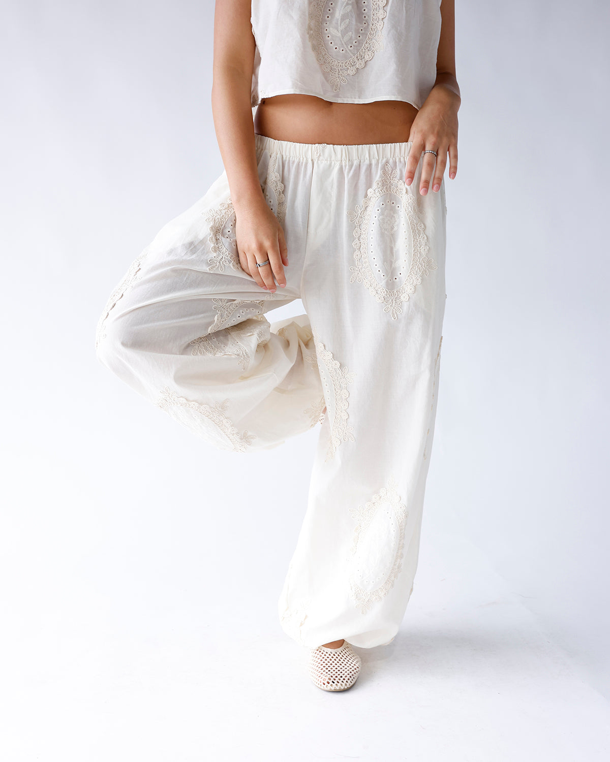 White wide-leg pants with beige lace medallion embroidery and elastic waistband