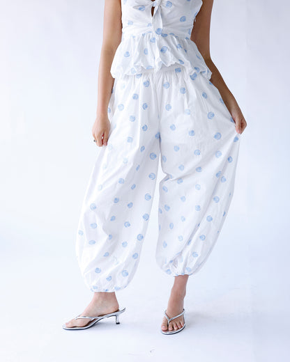 White balloon pants featuring an allover seashell print and an easy slide-on design. These relaxed, coastal-inspired pants are perfect for beach days, vacations, and effortless summer styling.
