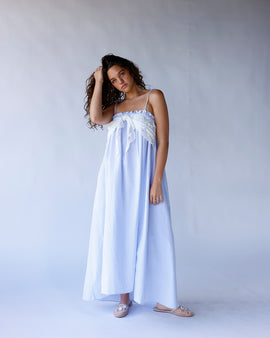 Blue and white striped long dress with spaghetti straps, elastic top, and lace front tie detail. A breezy, coastal-inspired summer dress perfect for vacations and warm days.