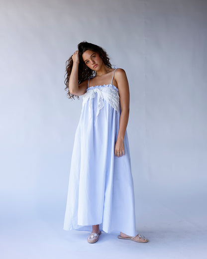 Blue and white striped long dress with spaghetti straps, elastic top, and lace front tie detail. A breezy, coastal-inspired summer dress perfect for vacations and warm days.
