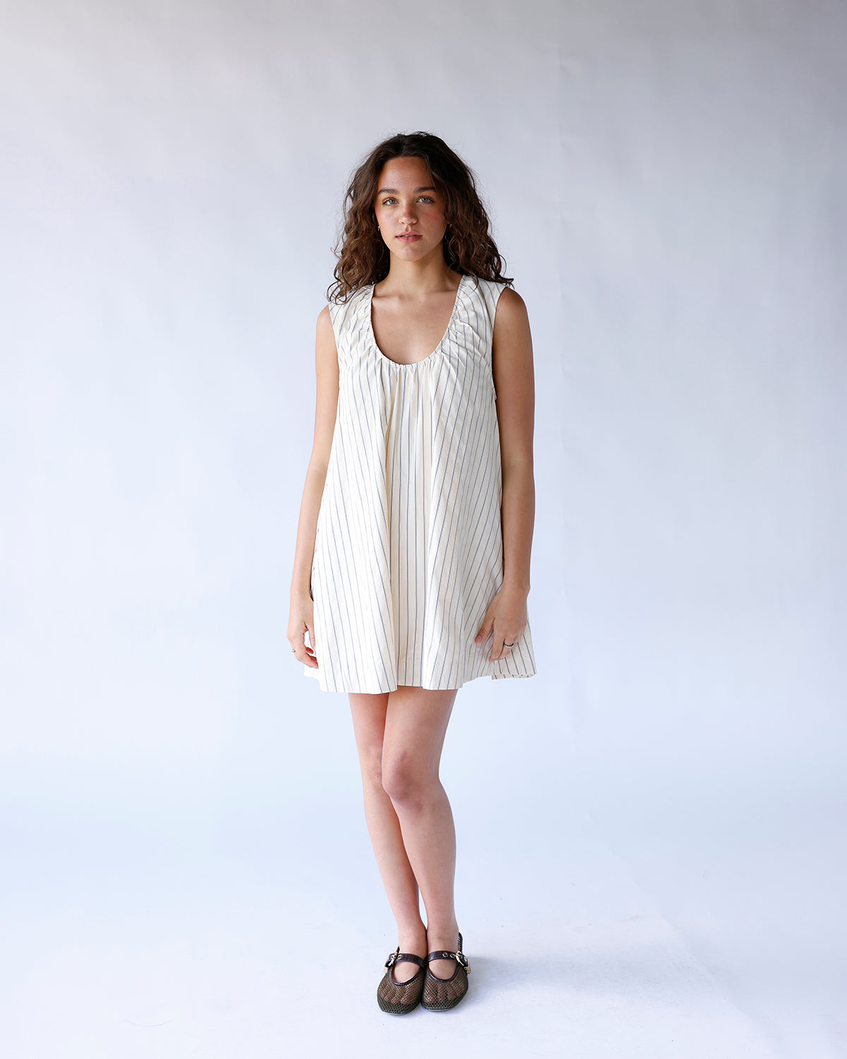 Cream pinstripe sleeveless mini dress with scoop neck and relaxed A-line silhouette