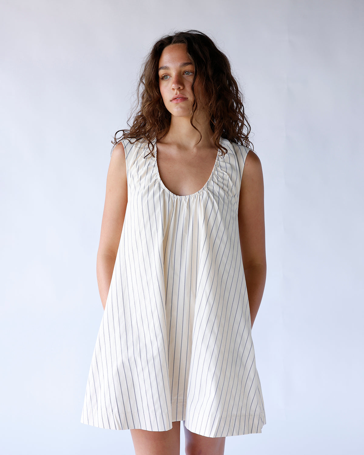 Cream pinstripe sleeveless mini dress with scoop neck and gathered bodice