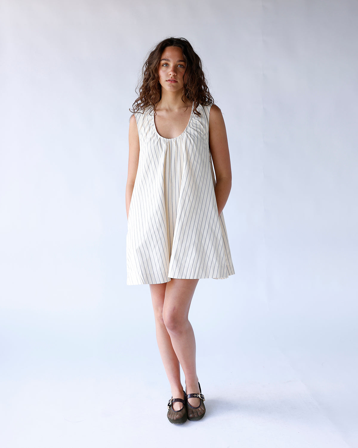 Cream pinstripe sleeveless mini dress with scoop neck and A-line silhouette