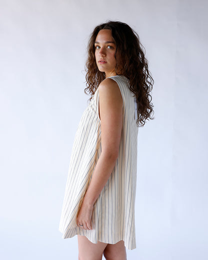 Cream striped sleeveless mini dress with relaxed fit, side view on model