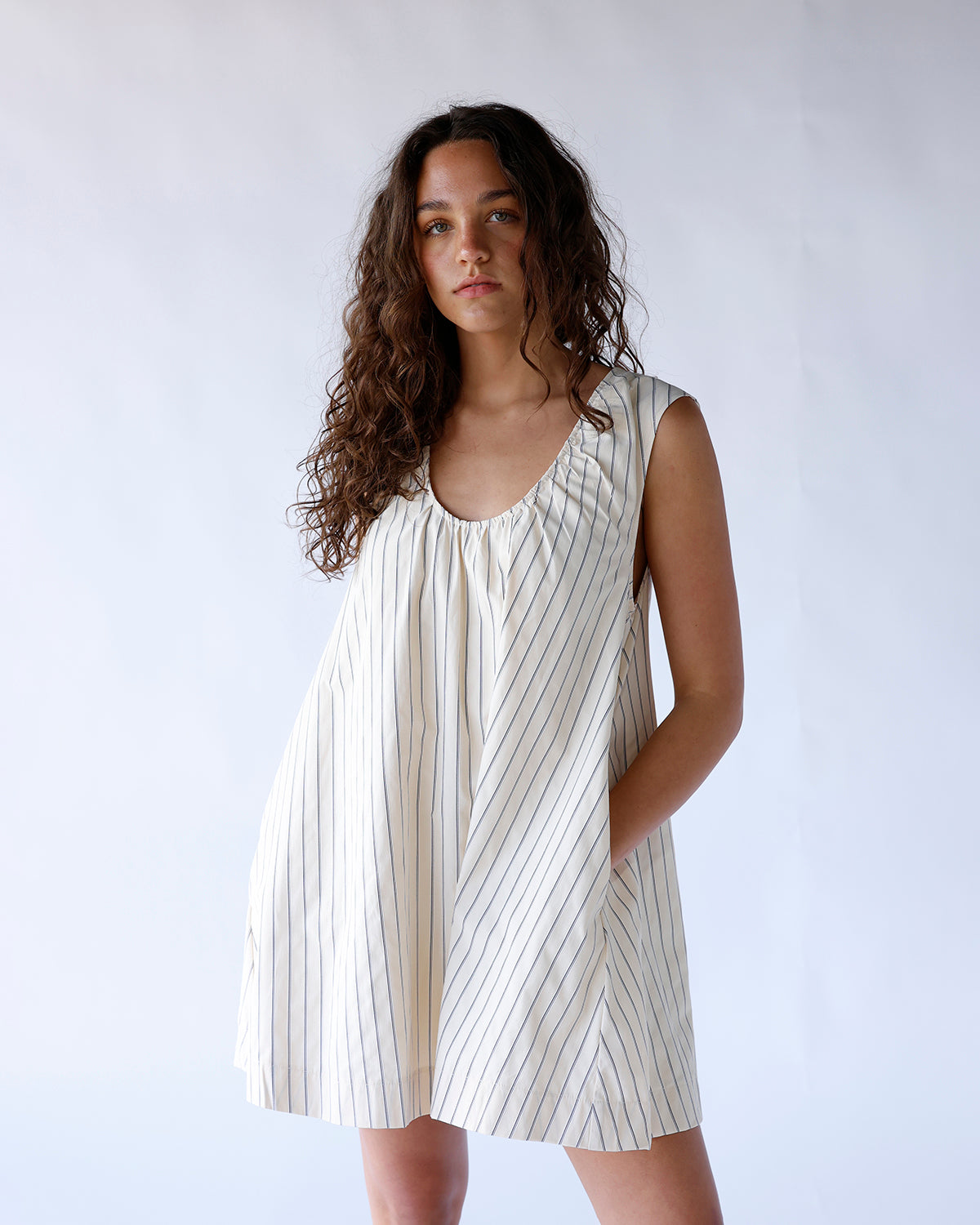 Cream striped sleeveless mini dress with gathered neckline and relaxed silhouette