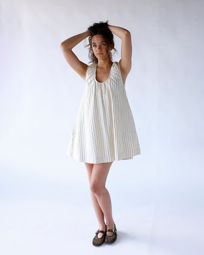 Cream striped sleeveless mini dress with deep scoop neck and flared skirt