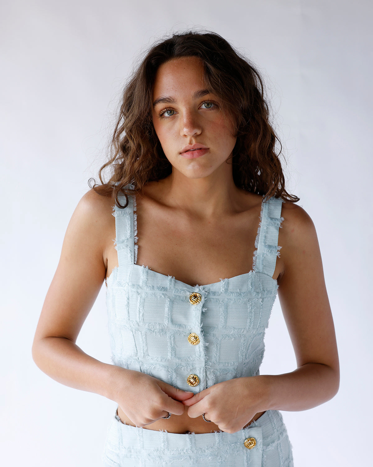 Shop our mint crop top and matching skort set featuring thick straps, three gold buttons, and textured shaggy square details. A chic and playful boutique set perfect for spring and summer.