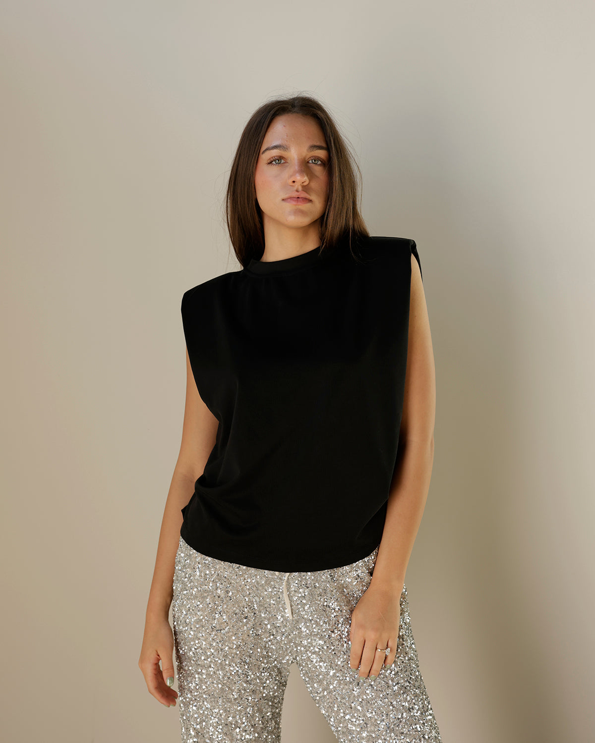 girl wearing black dressy muscle Tshirt blouse with silver sequin pants her hair is down 