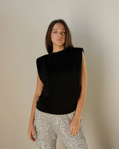 girl wearing black dressy muscle Tshirt blouse with silver sequin pants her hair is down 