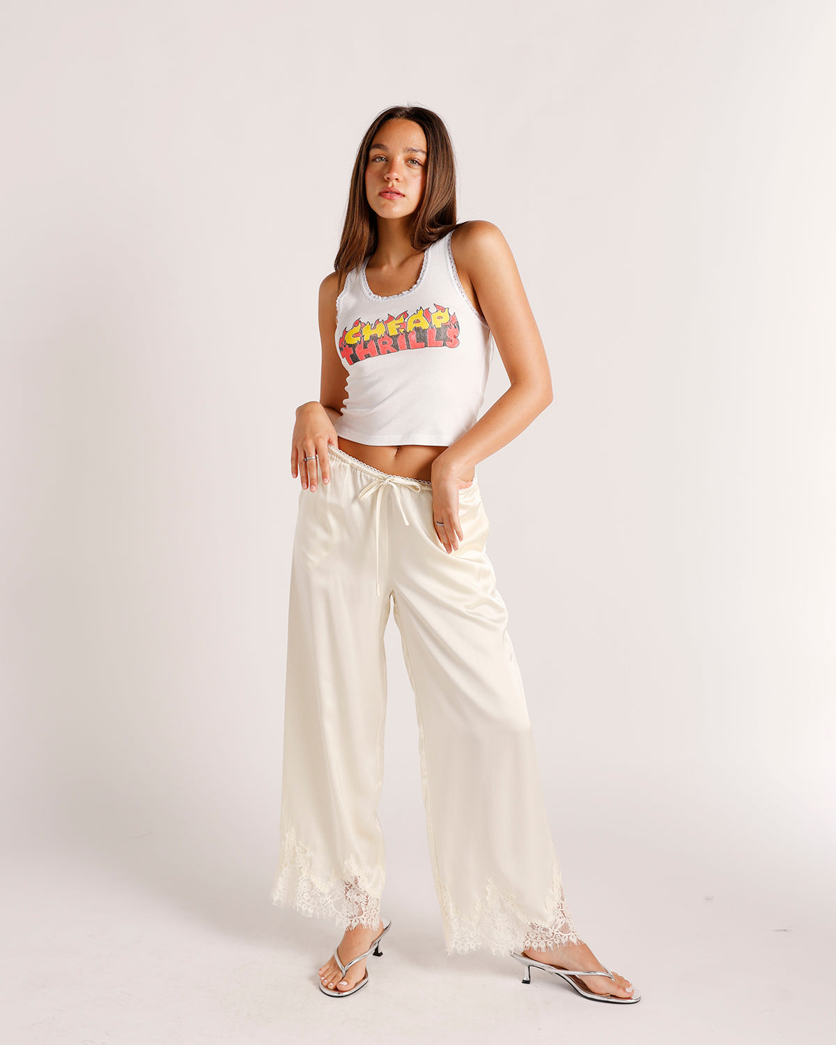 Cream satin wide-leg pants with lace hem trim and drawstring waist
