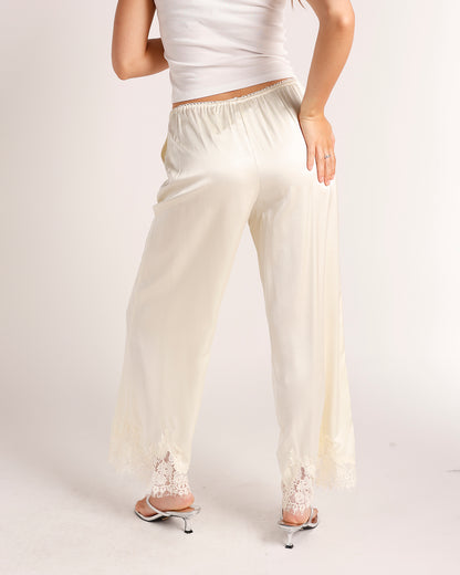Cream satin wide-leg pants with lace trim hem and elastic waistband, back view