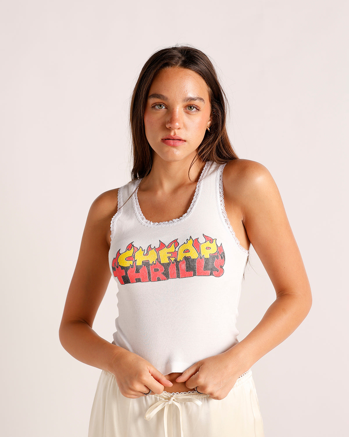 White sleeveless tank top with flame graphic print reading Cheap Thrills, lace trim