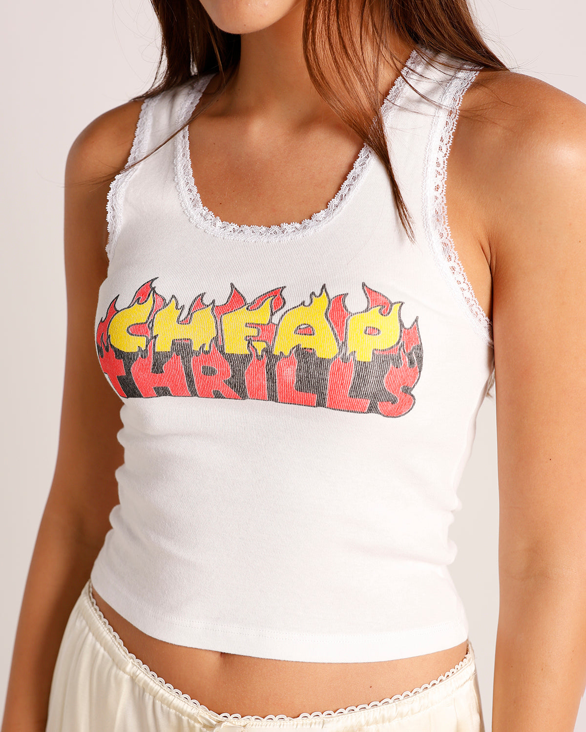 White ribbed lace-trim crop tank top with flame graphic print reading Cheap Thrills