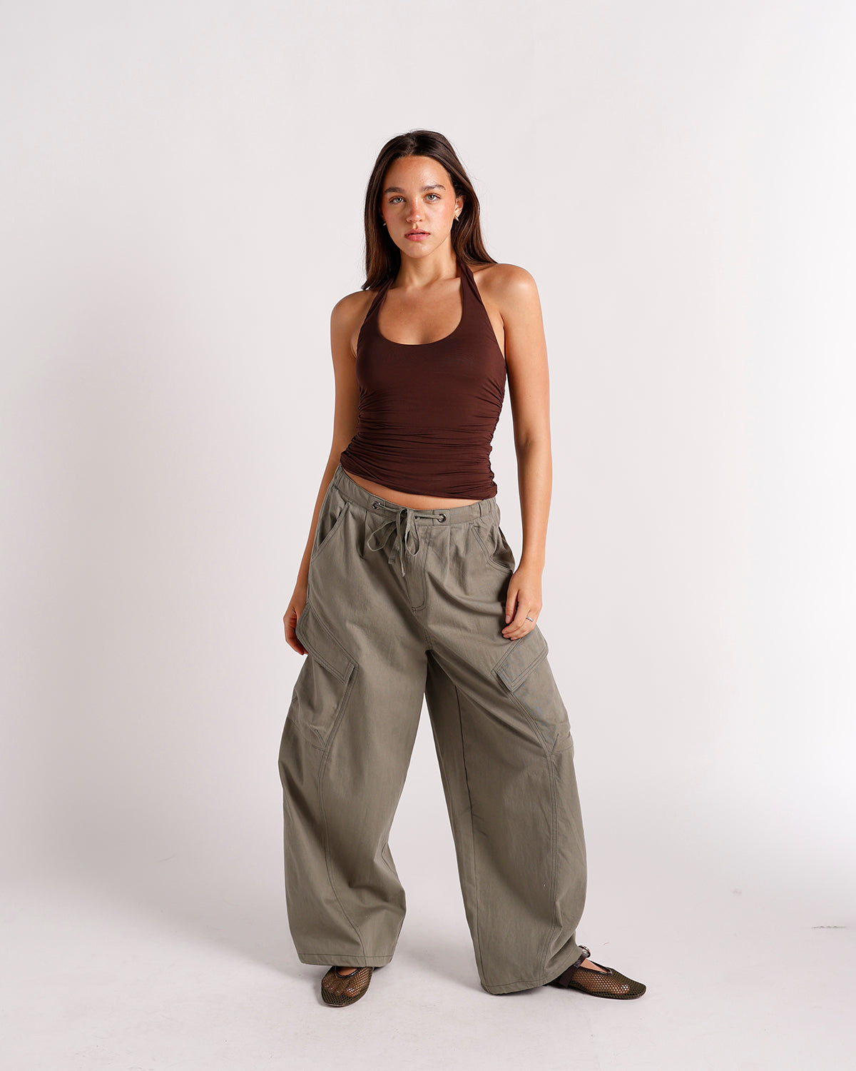 Dark brown ruched halter top with scoop neckline, worn with wide-leg cargo pants