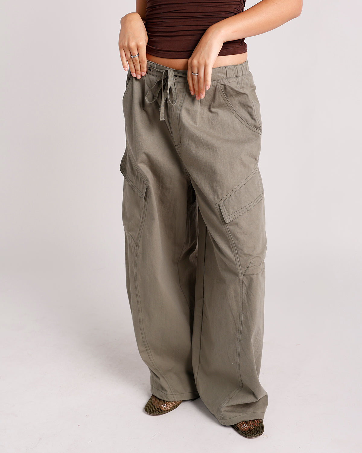 Olive green wide-leg cargo pants with drawstring waist and large side pockets