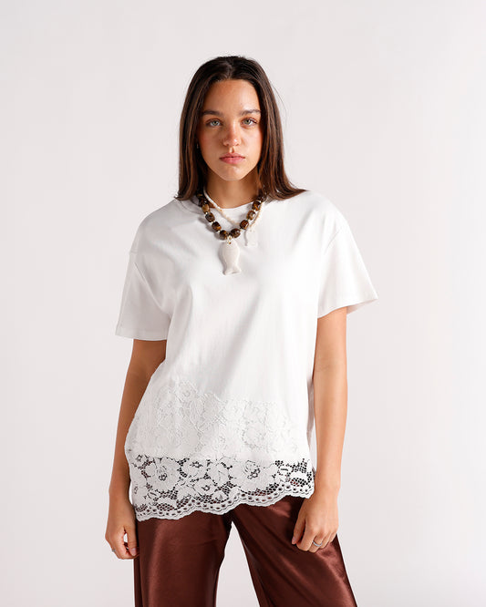 White oversized short-sleeve top with floral lace hem trim, styled with brown satin pants