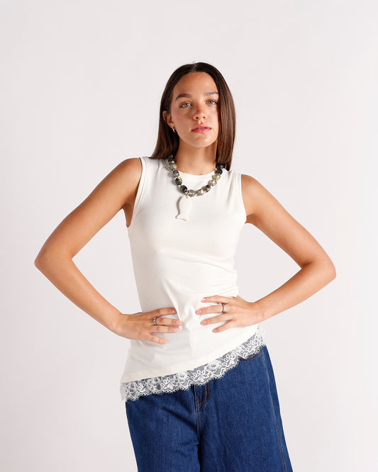 sleeveless white tank top with lace trim detailing at hemline