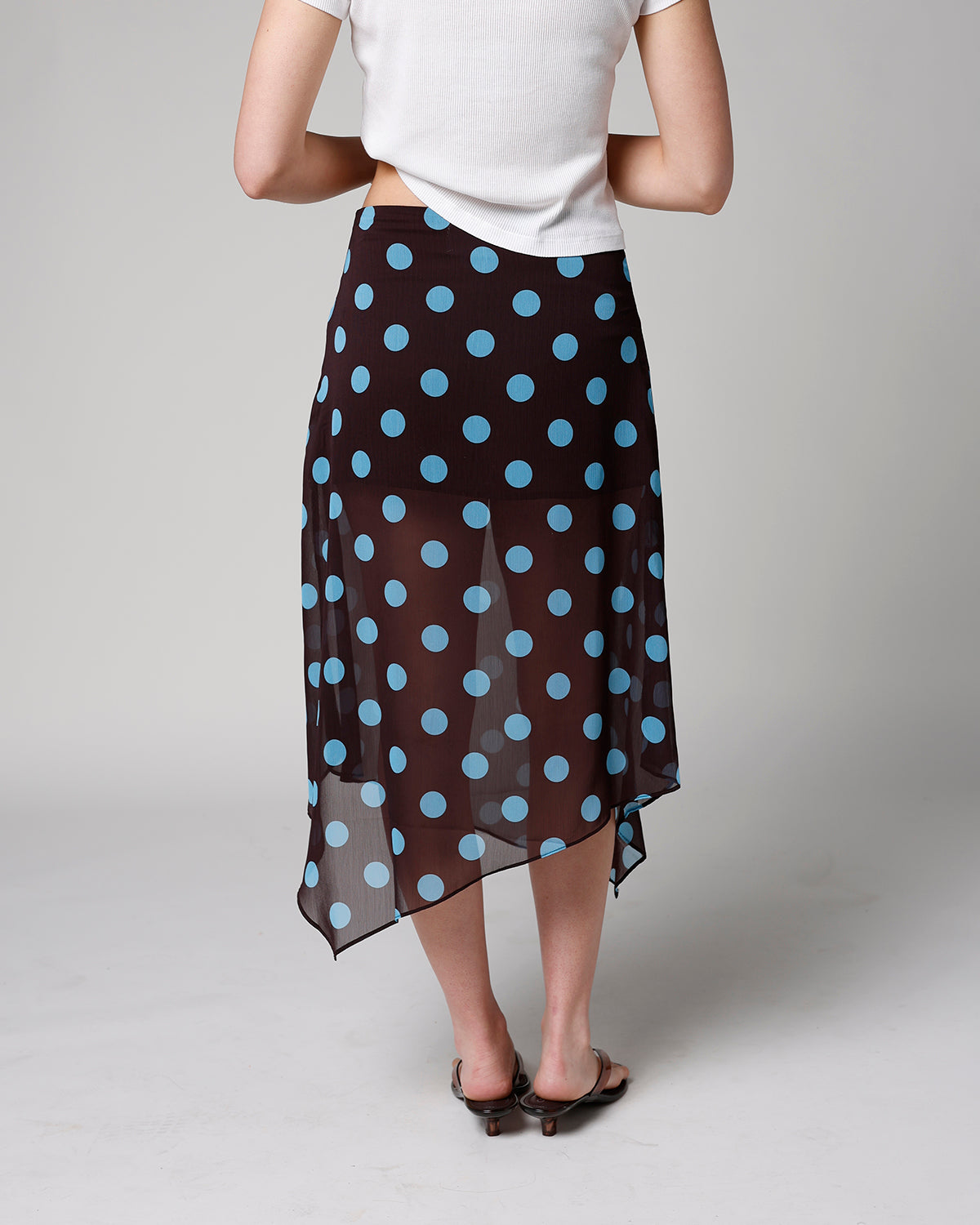 Black sheer midi skirt with blue polka dots and asymmetrical handkerchief hem