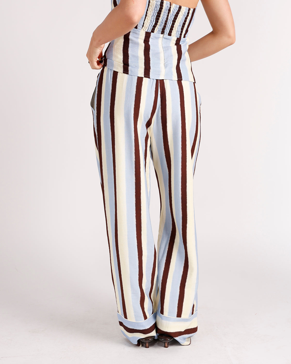 Women's wide-leg striped pants in blue, cream, and brown with smocked waistband