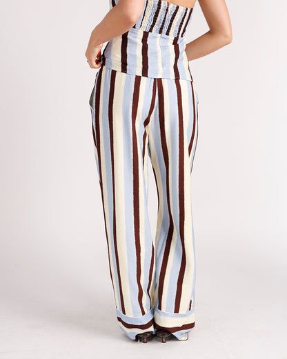 Women's wide-leg striped pants in blue, cream, and brown with smocked waistband
