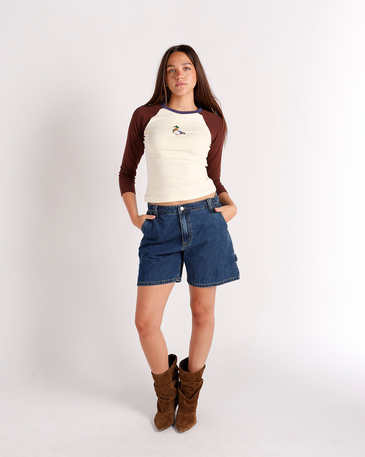 Cream and brown raglan long-sleeve top with duck embroidery, worn with denim shorts