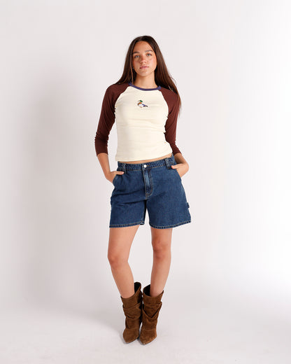 Cream and brown raglan long-sleeve top with duck embroidery, worn with denim shorts