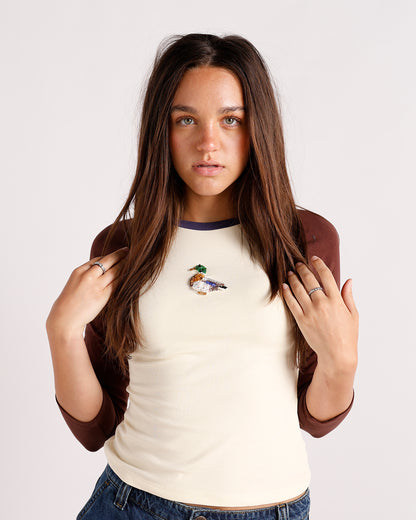 Cream and brown raglan top with embroidered duck brooch and navy collar