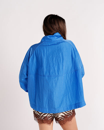 Oversized blue windbreaker jacket, back view, worn with zebra print lace-trim shorts