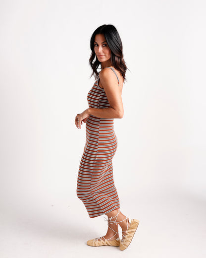 Rust striped sleeveless midi dress with form-fit silhouette, paired with lace-up sandals