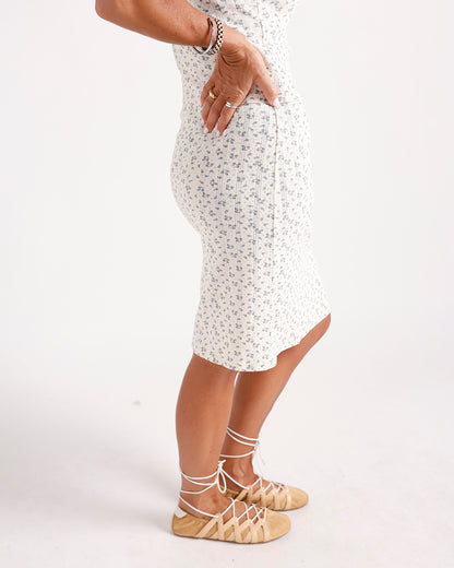White floral midi dress with blue ditsy print, worn with lace-up tan sandals