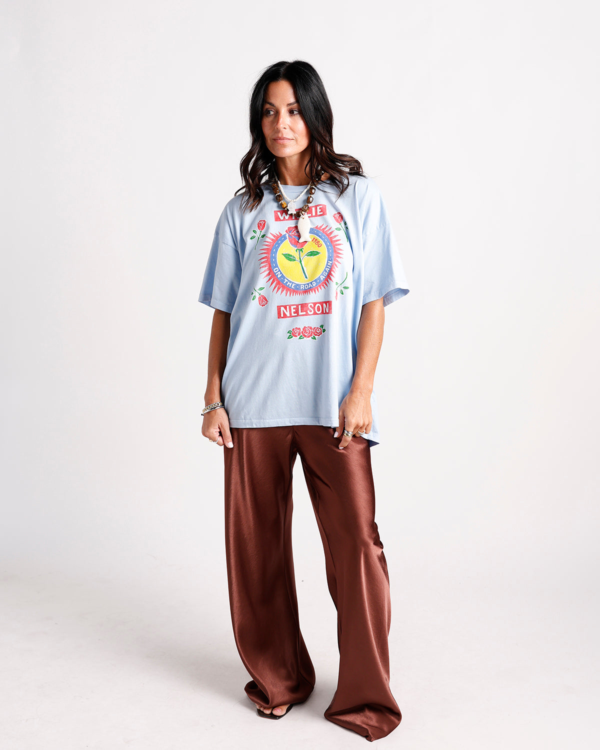Oversized light blue graphic band tee with brown wide-leg satin pants