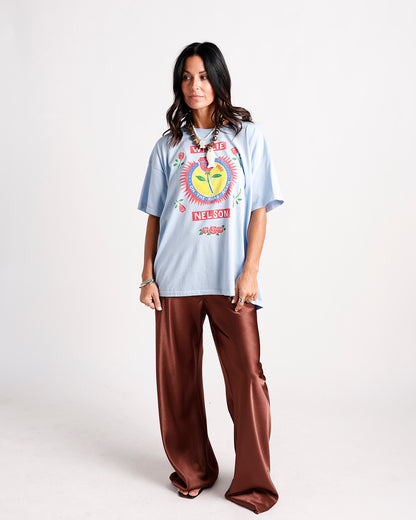 Oversized light blue graphic band tee with brown wide-leg satin pants
