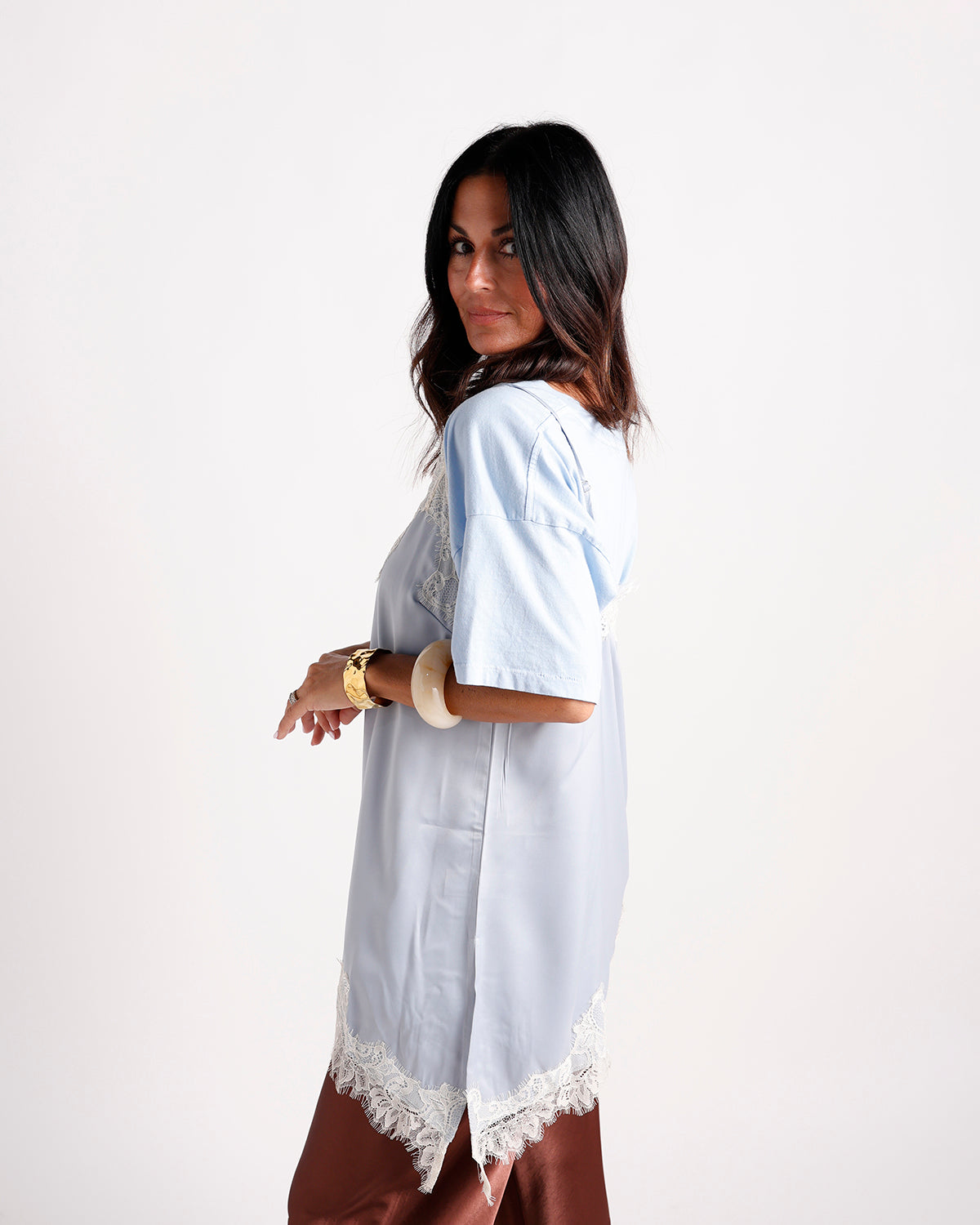 Light blue satin short-sleeve top with white lace trim hem, side view