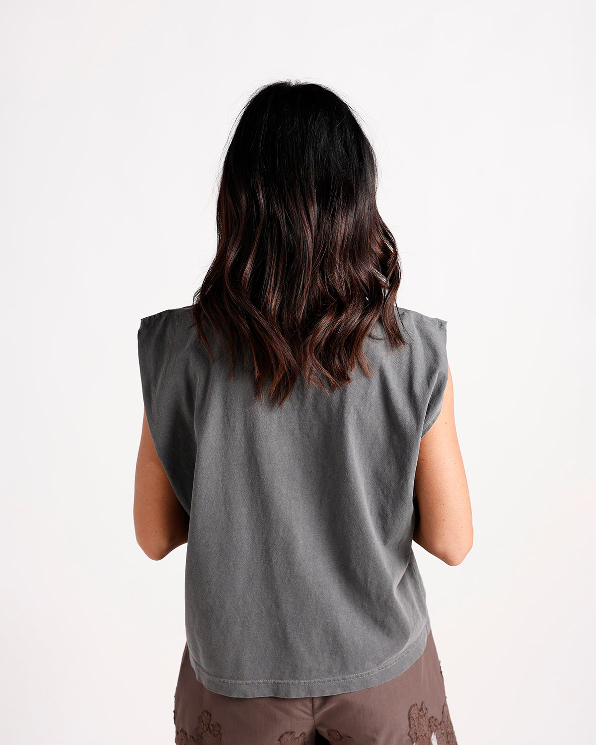 Back view of a charcoal gray sleeveless muscle tee with structured shoulders