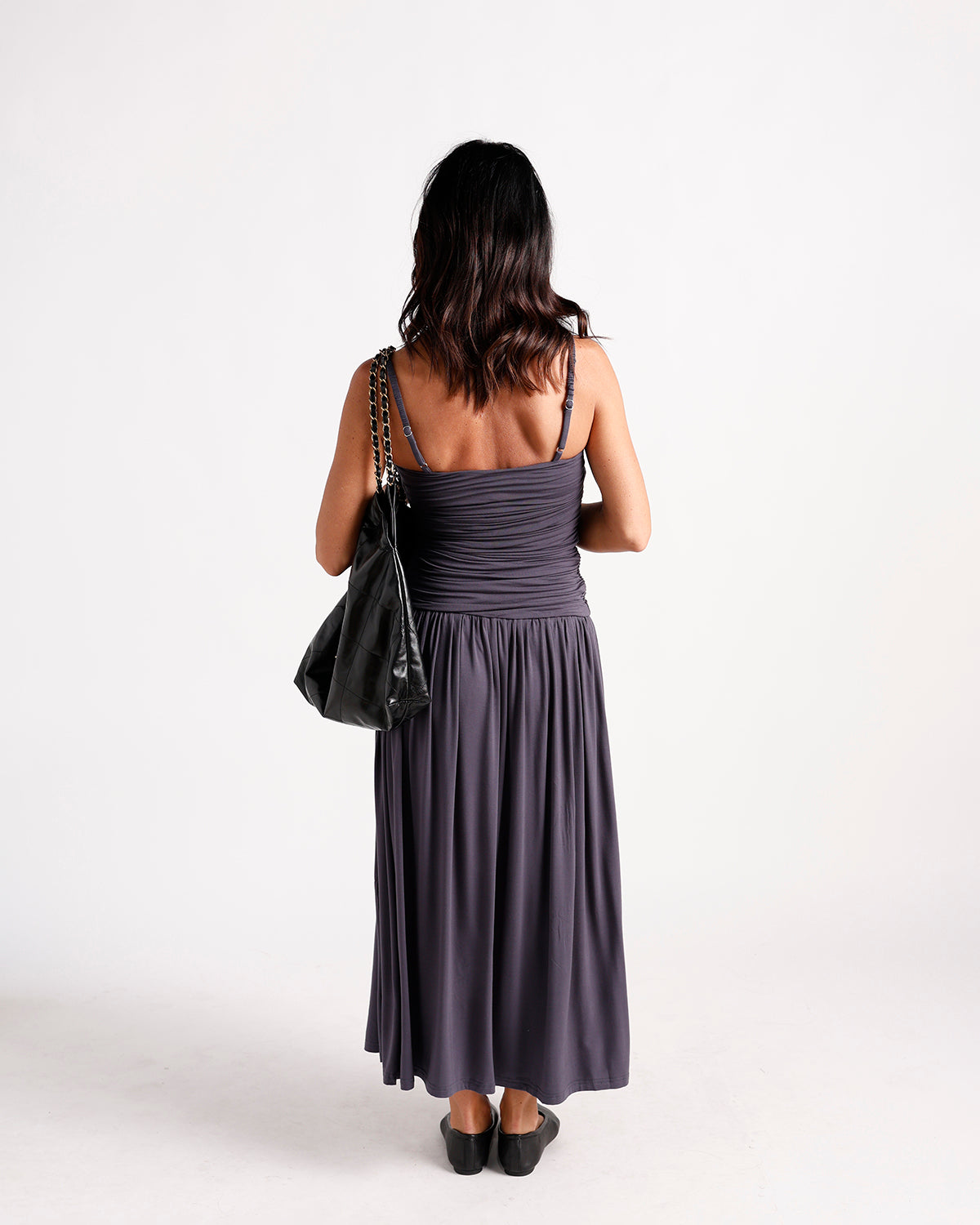 Dark gray ruched maxi dress with spaghetti straps, shown from back view