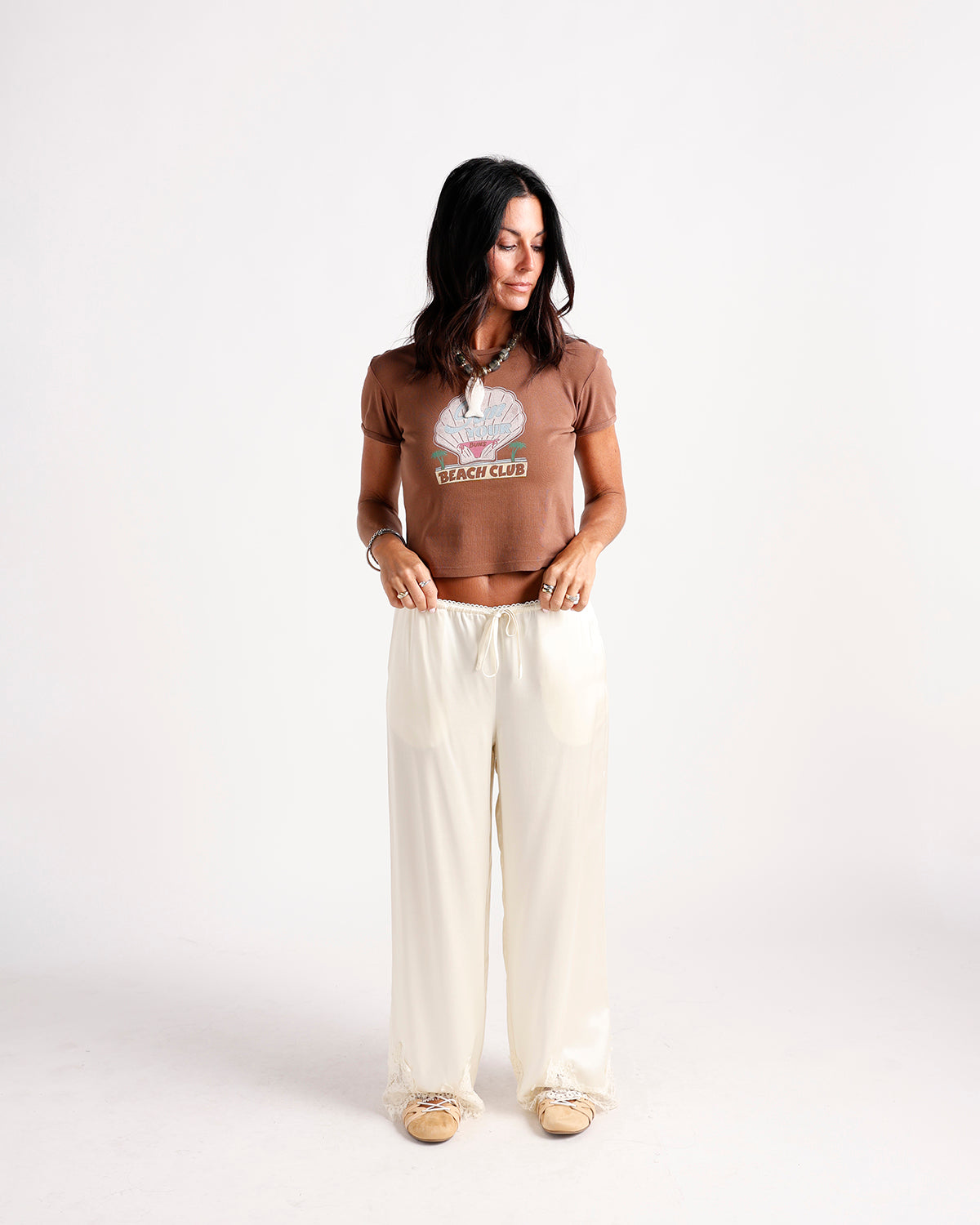 Cream wide-leg pants with lace trim waistband and hem, drawstring detail