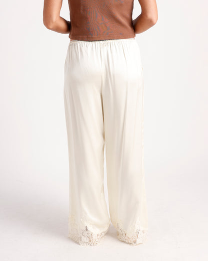 Cream satin wide-leg pants with elastic waist and lace trim hem, back view