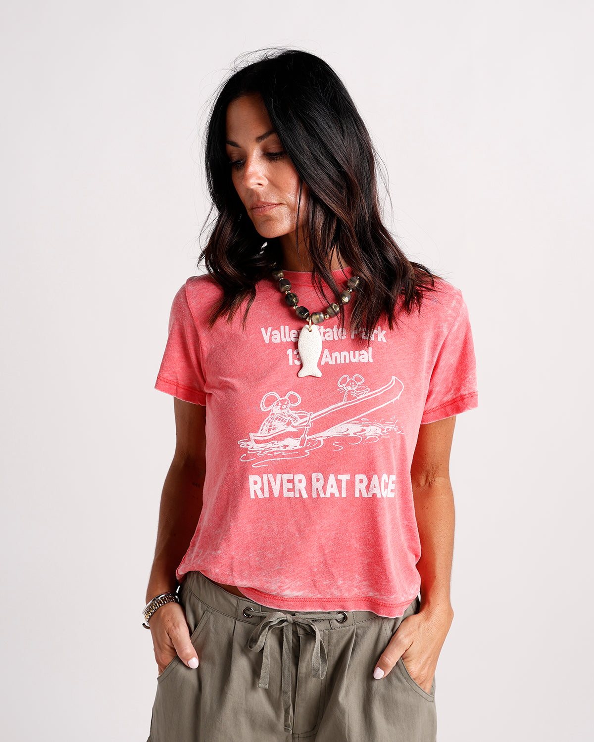 Washed coral graphic tee with River Rat Race print, worn with olive drawstring pants