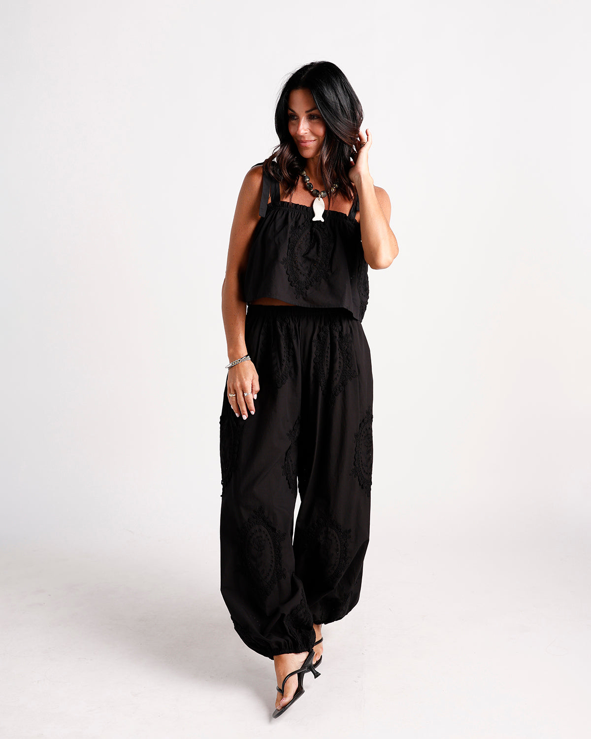 Black wide-leg dressy pants with tonal embroidered medallion details and elasticated ankles