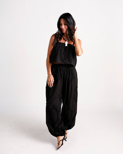 Black wide-leg dressy pants with tonal embroidered medallion details and elasticated ankles