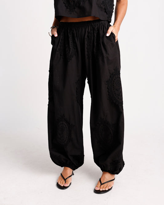 Black wide-leg harem pants with floral lace appliqué and elasticated ankles