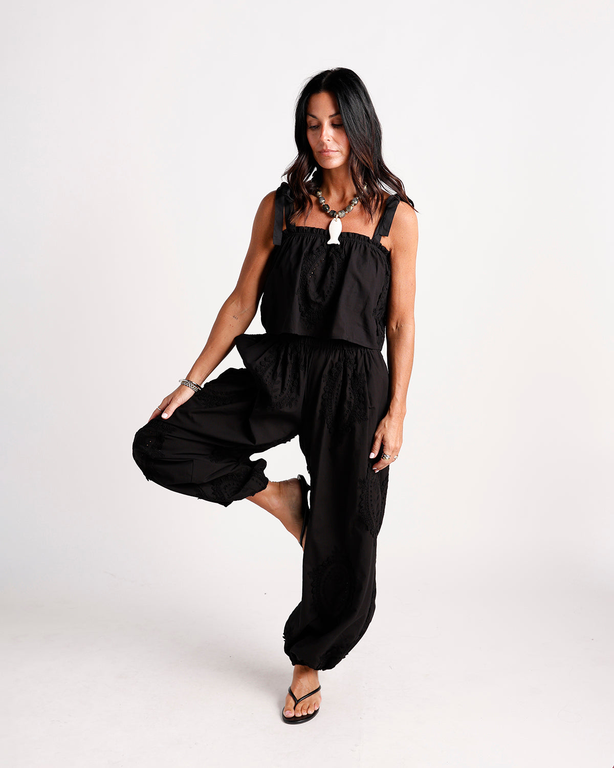 Black wide-leg dressy pants with lace panels and elasticated ankles, modeled standing