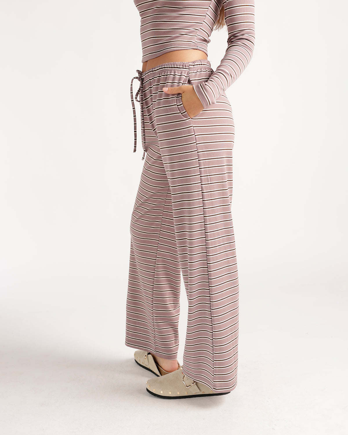 Relax in effortless style with these mauve striped wide-leg pants featuring a comfortable drawstring waistband, flowy silhouette, and retro-inspired stripe pattern. Perfect as a matching set or styled with your favorite basics for a cozy, chic look made for weekends, lounging, and everyday wear.